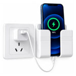 White wall mounted adhesive phone holder next to wall socket while smartphone charges